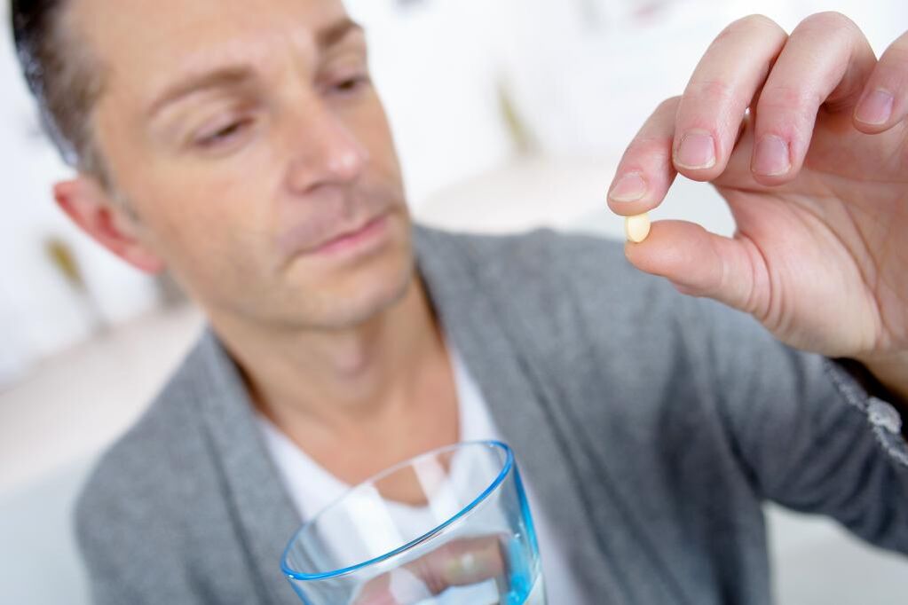a man drinks a pill to increase his potency